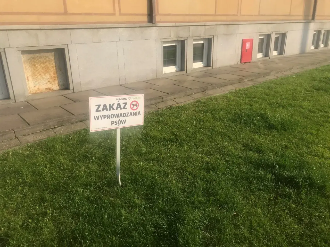 Tabliczka informuje o zakazie wyprowadzania psów na terenie wspólnoty.