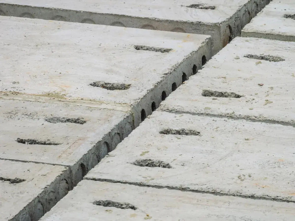 Reihen von Betonplatten mit rechteckigen Aussparungen. Die faserbeton mindestdicke ist hier gut erkennbar.
