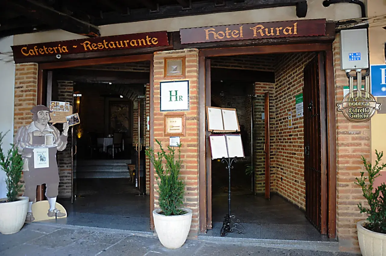 Entrada a Cafetería-Restaurante y Hotel Rural. Un cartel de un camarero invita a descubrir dónde comer en Guadalupe.