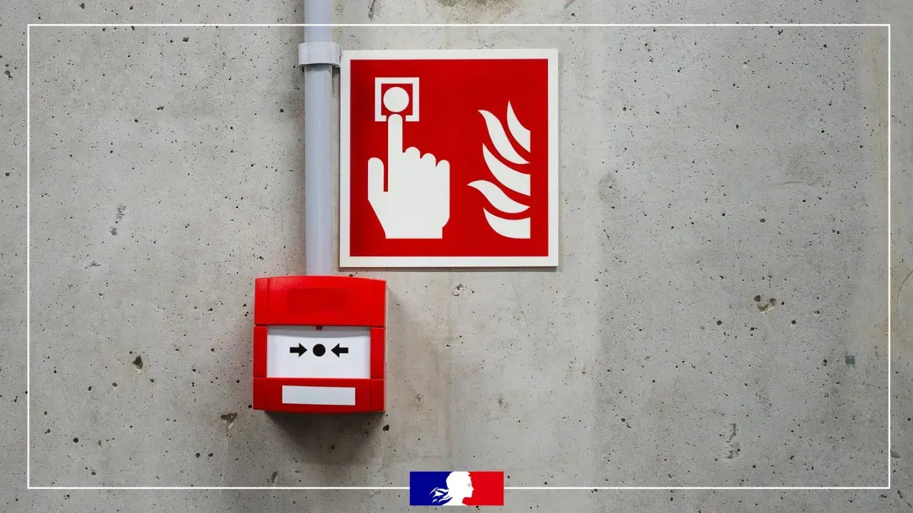 Déclencheur rouge et panneau d'alarme incendie sur mur de béton. En cas de danger, le bruit d'alarme incendie retentira.