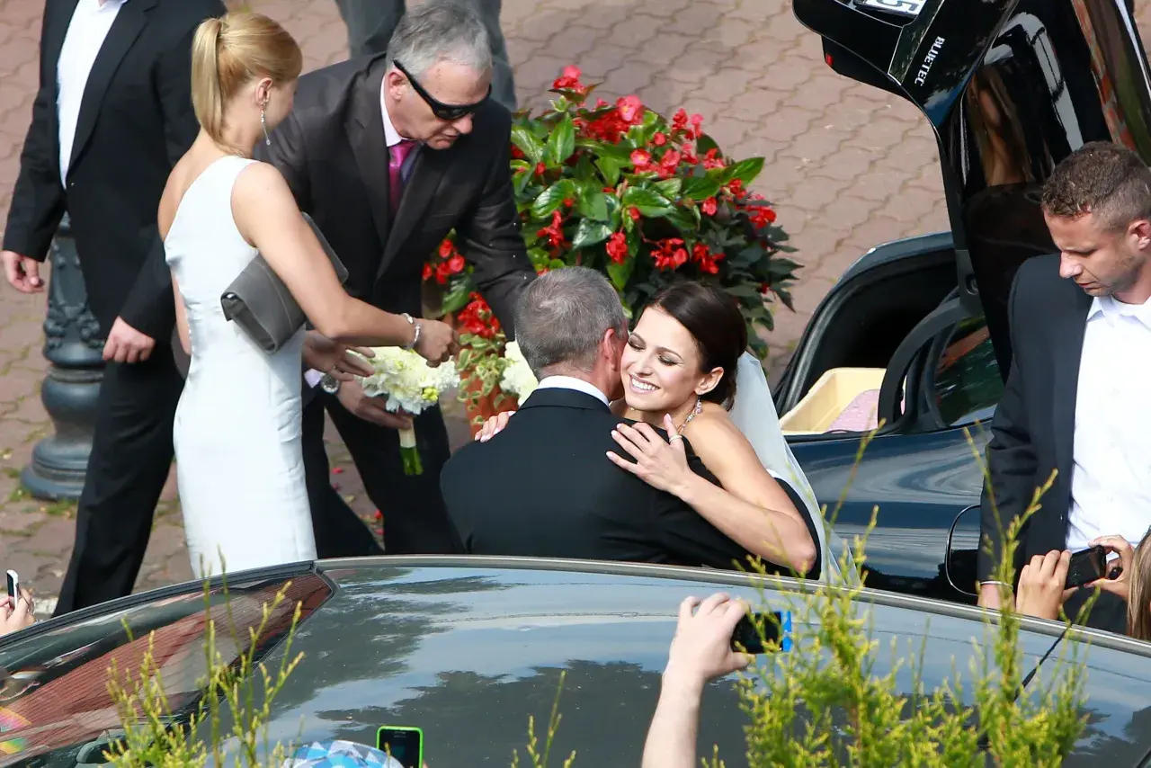 Szczęśliwa panna młoda w białej sukni przytula pana młodego. To piękny moment z ich ślubu, być może Roberta Lewandowskiego.