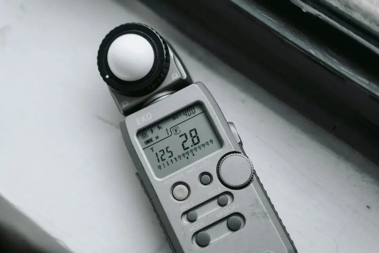 Srebrna jednostka oświetlenia EKO z kulistym dyfuzorem i wyświetlaczem pokazującym ISO 400, czas 125 i przysłonę 2.8.