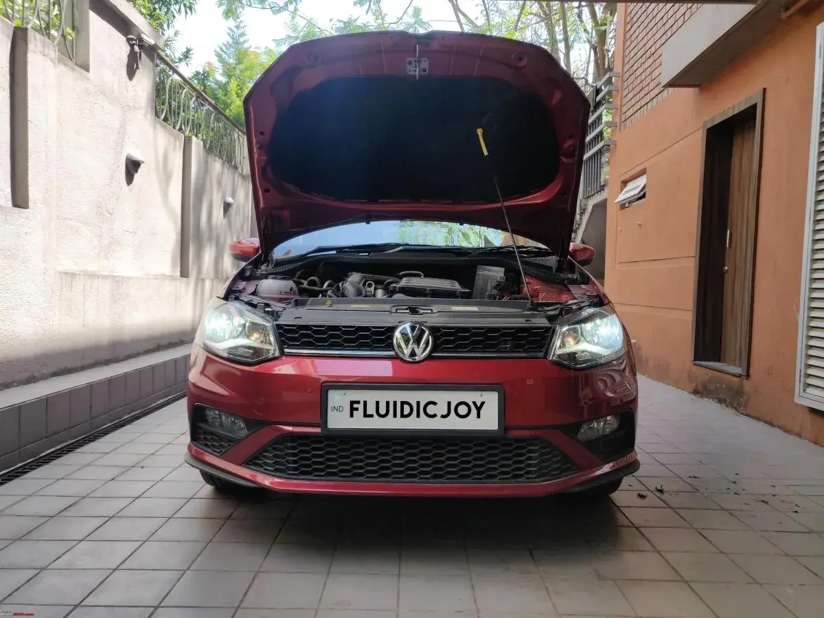 Czerwony VW Polo z otwartą maską, gotowy do wymiany żarówki H7.