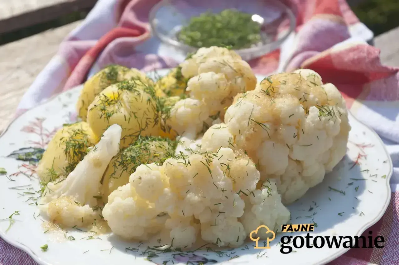 Gotowany kalafior i ziemniaki polane sosem, posypane koperkiem. Idealna zasmażka do kalafiora sprawia, że danie jest pyszne.