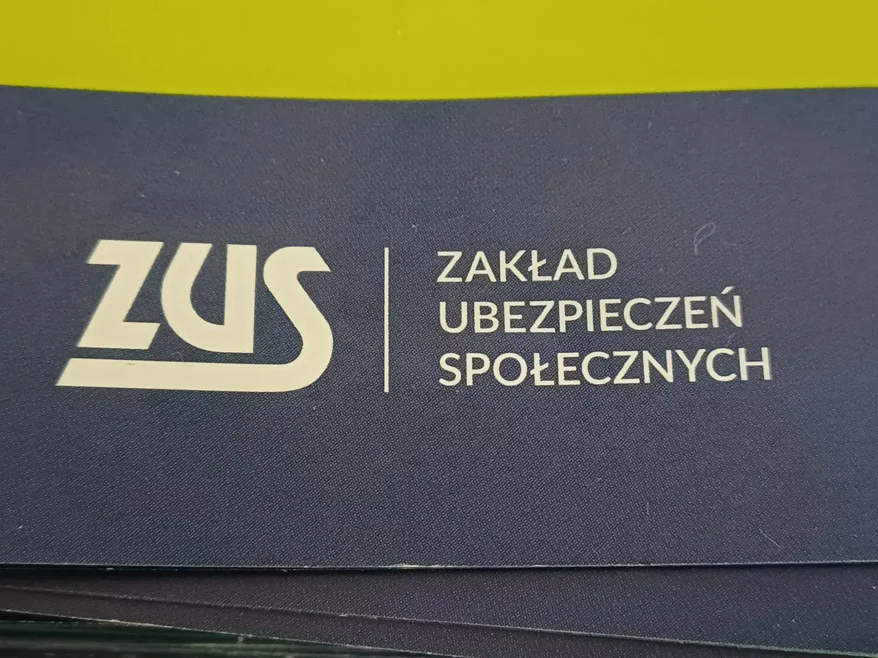 Logo ZUS (Zakład Ubezpieczeń Społecznych) na granatowym tle.