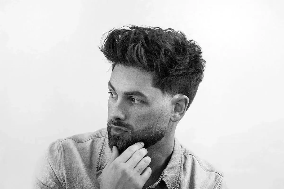 Dos cortes de pelo masculinos: un taper fade con diseño y un fade más pronunciado.