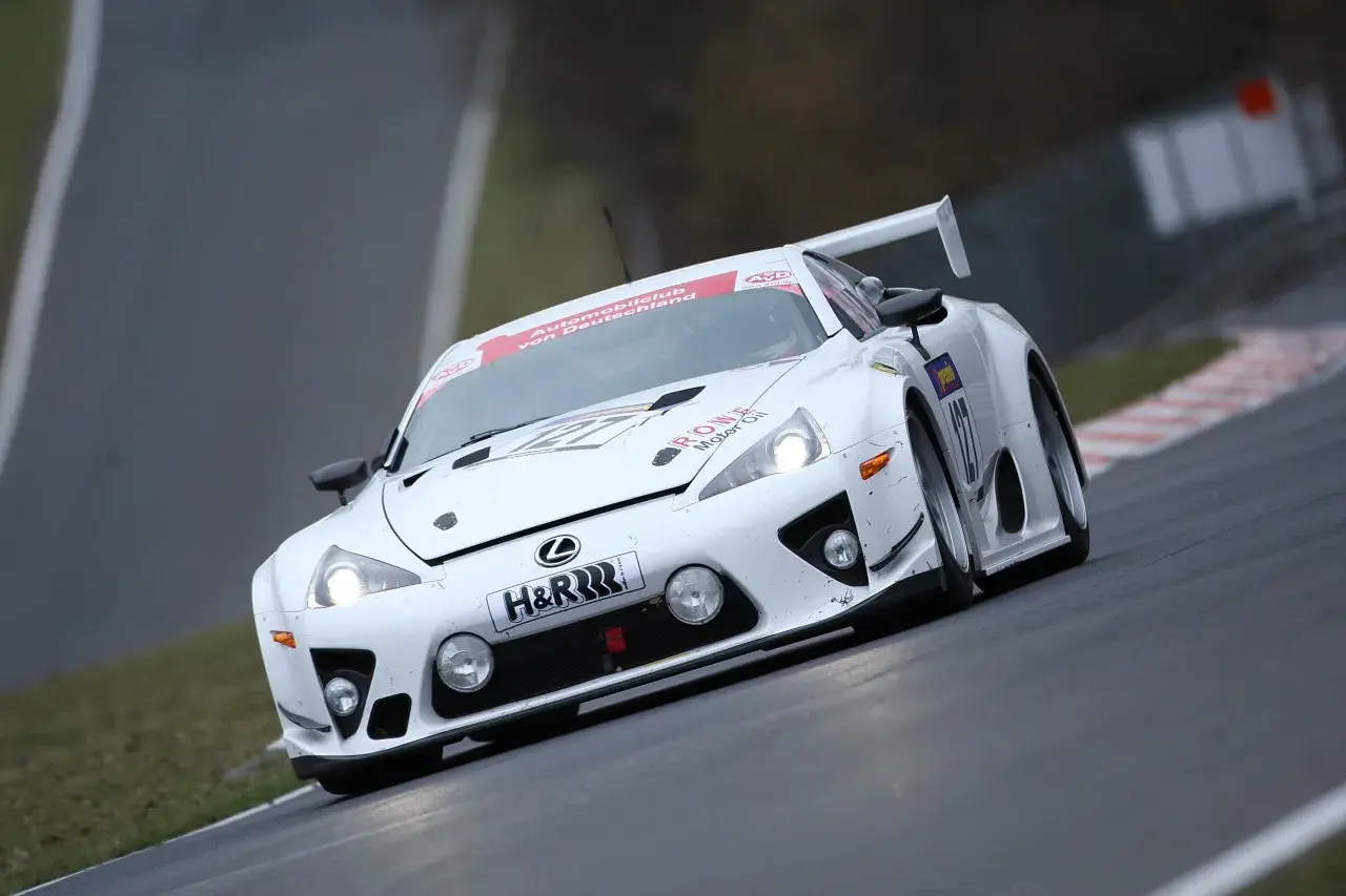 Biały Lexus LFA na torze wyścigowym, z numerem 127 i logiem H&R.