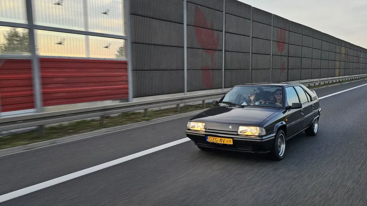 Czarny Citroën BX z zabytkowymi tablicami rejestracyjnymi jedzie autostradą.