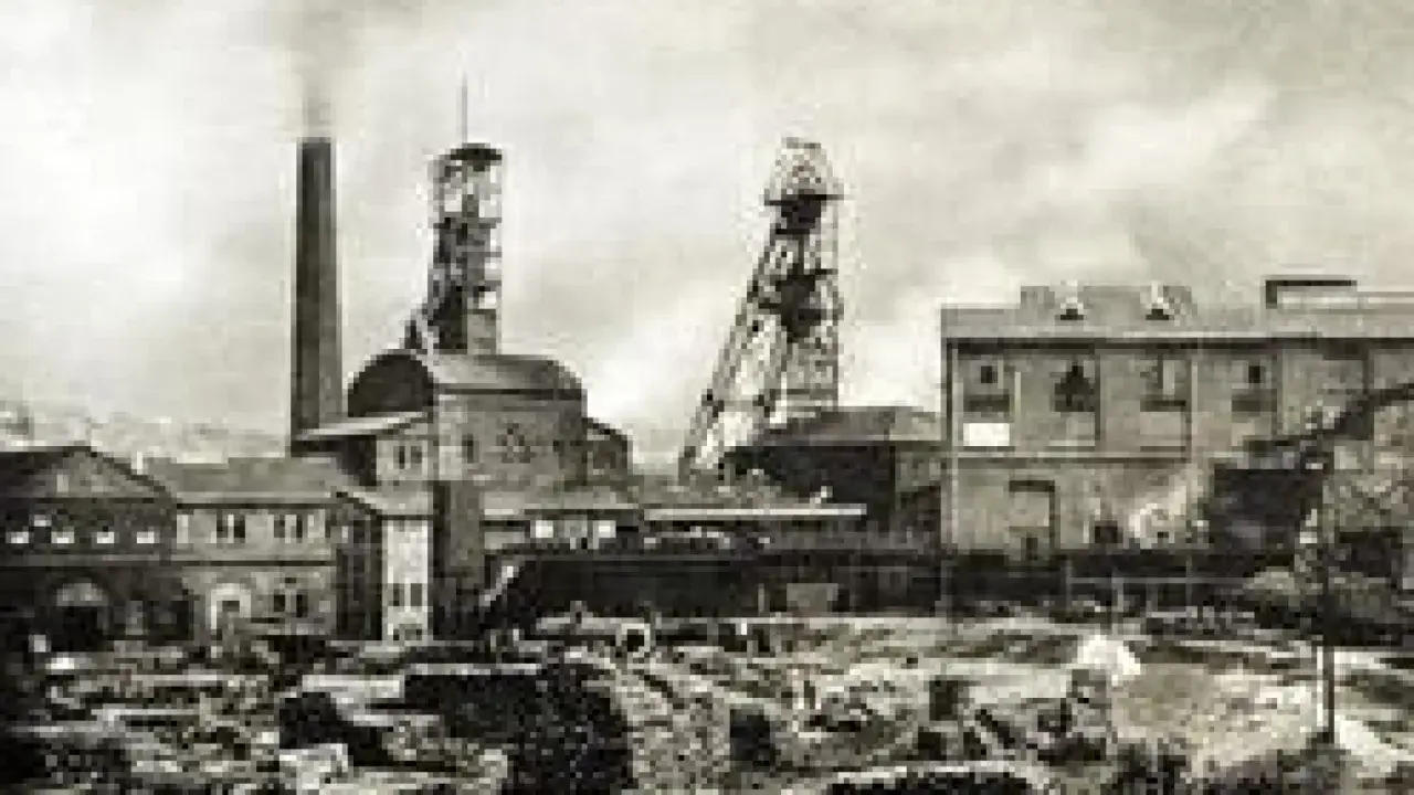 Industrielle Anlage mit Schornstein und Fördertürmen. Hier wurde einst die Grundlage für Kohle und Stahl geschaffen.