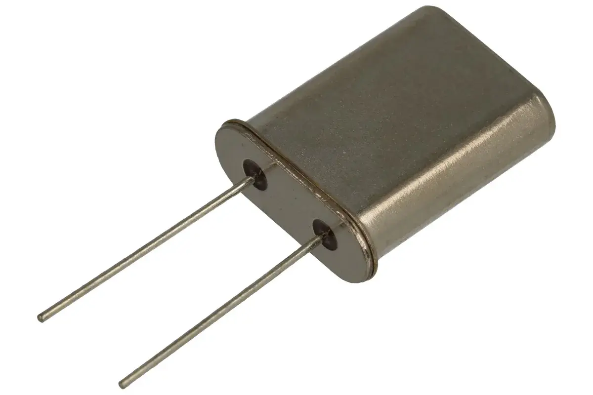 Metalowa obudowa z dwoma pinami, typowy rezonator kwarcowy, kluczowy element w elektronice do stabilizacji częstotliwości.