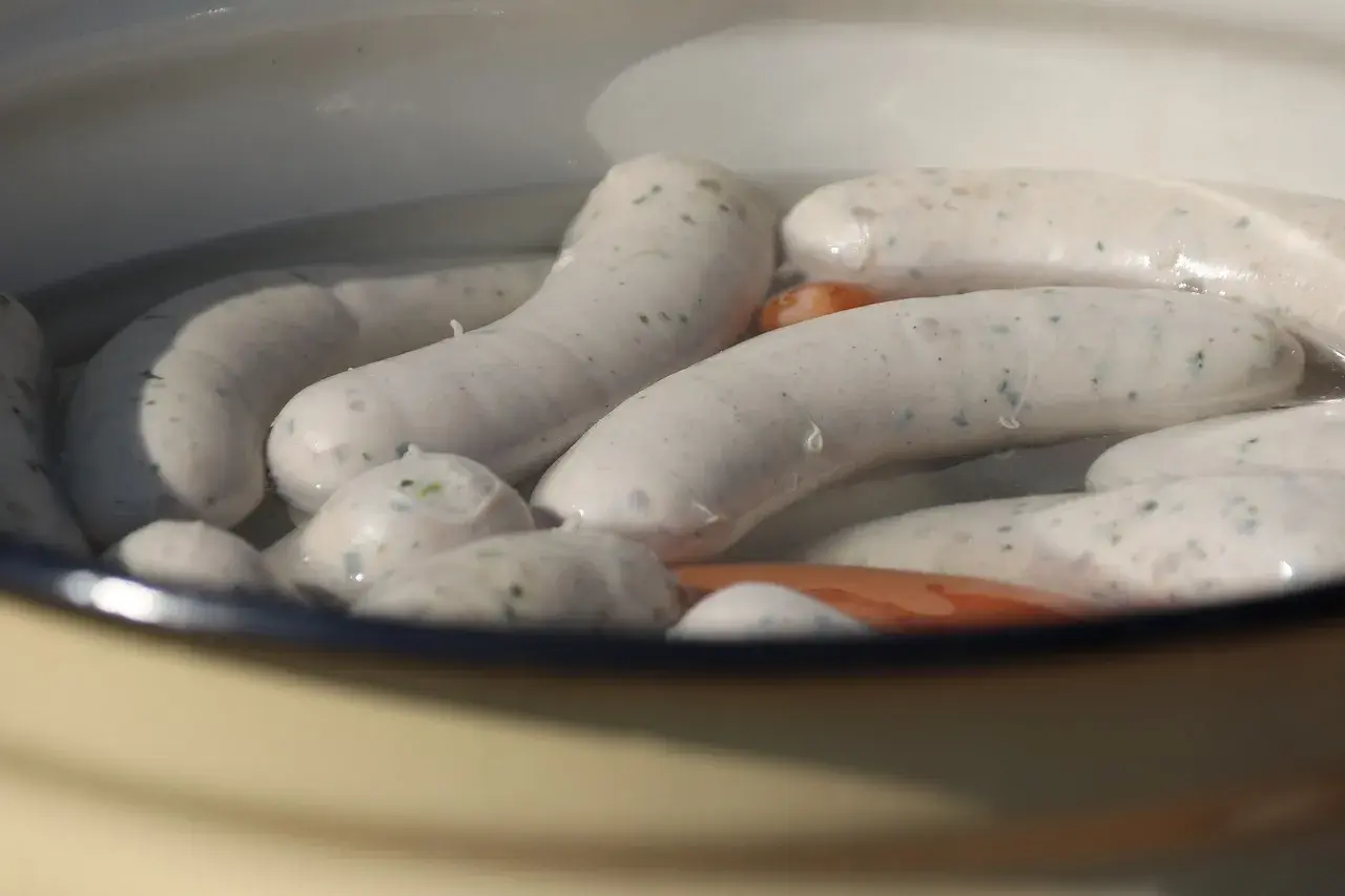 Weiße Würste garen in heißem Wasser. Die Frage "wie lange Wiener kochen" beschäftigt viele Hobbyköche.