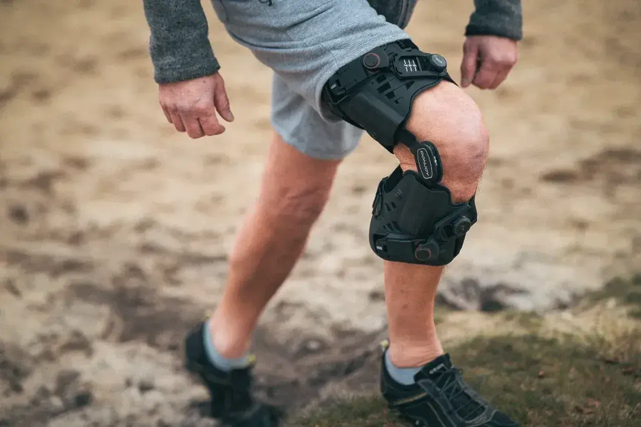 Mann mit Knieorthese, die bei einem Innenbandriss am Knie hilft.