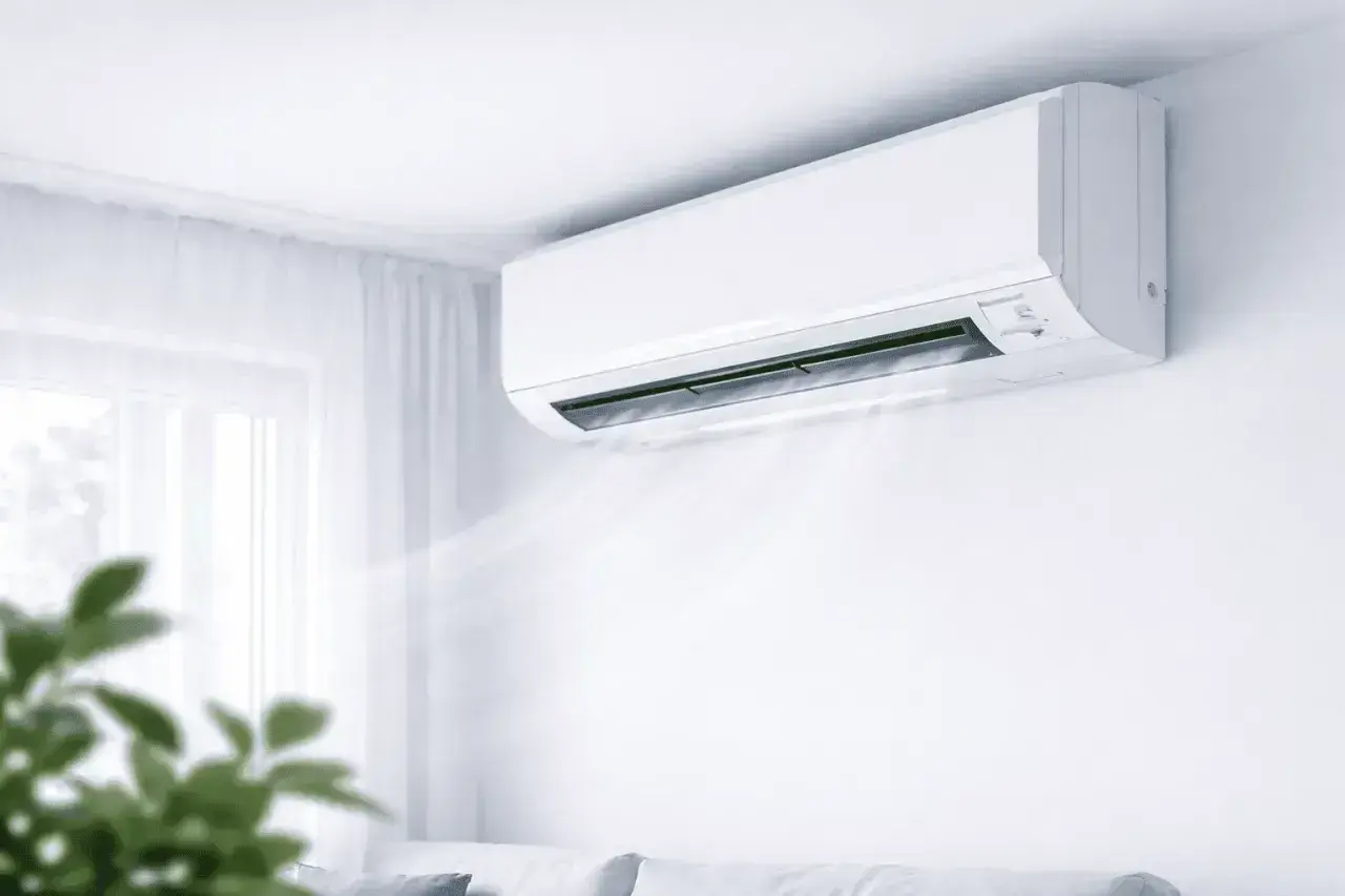 Biała jednostka klimatyzacyjna zamontowana na ścianie, wydmuchująca chłodne powietrze.