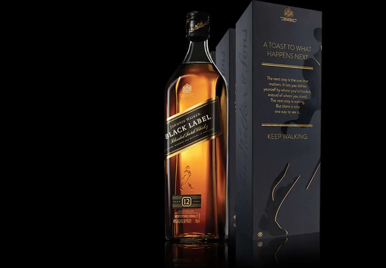 Elegancka butelka Johnnie Walker Black Label obok czarnego pudełka z cytatem "Keep Walking".