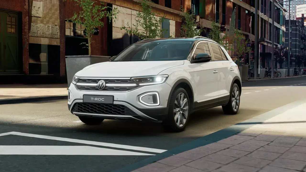 Biały Volkswagen T-Roc stoi na ulicy miejskiej, gotowy na kolejną przygodę.
