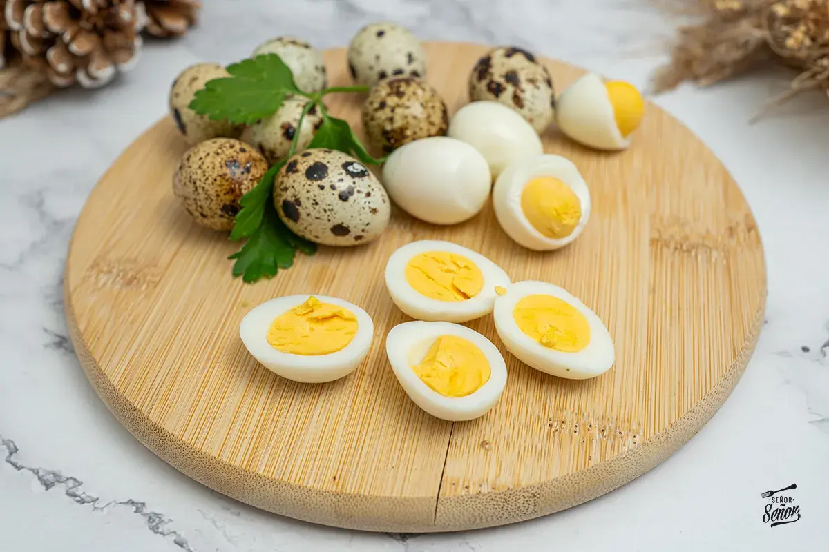 Huevos de codorniz cocidos y cortados por la mitad, mostrando sus yemas amarillas. Perfectos para una tapa o ensalada.