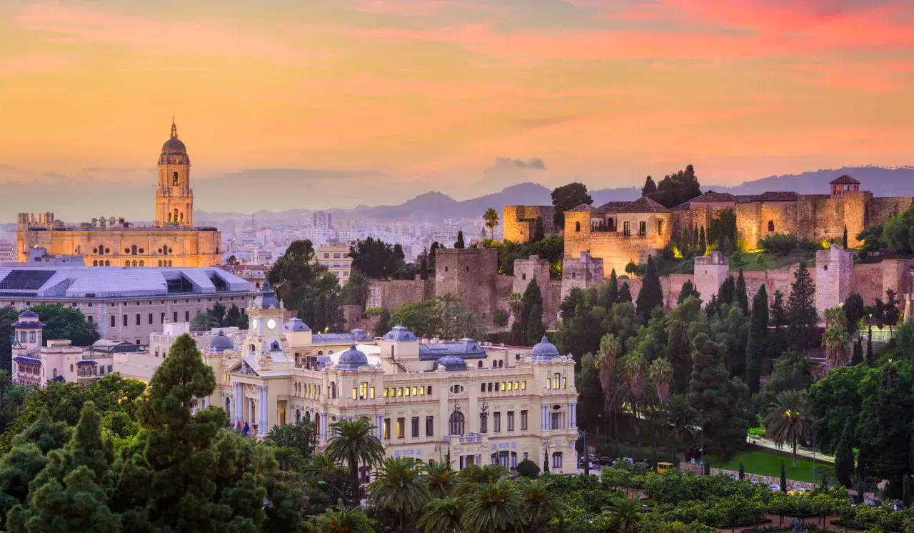Atardecer en Málaga, con la Alcazaba iluminada y la Catedral al fondo. Un lugar perfecto para disfrutar de actividades culturales y vistas impresionantes.
