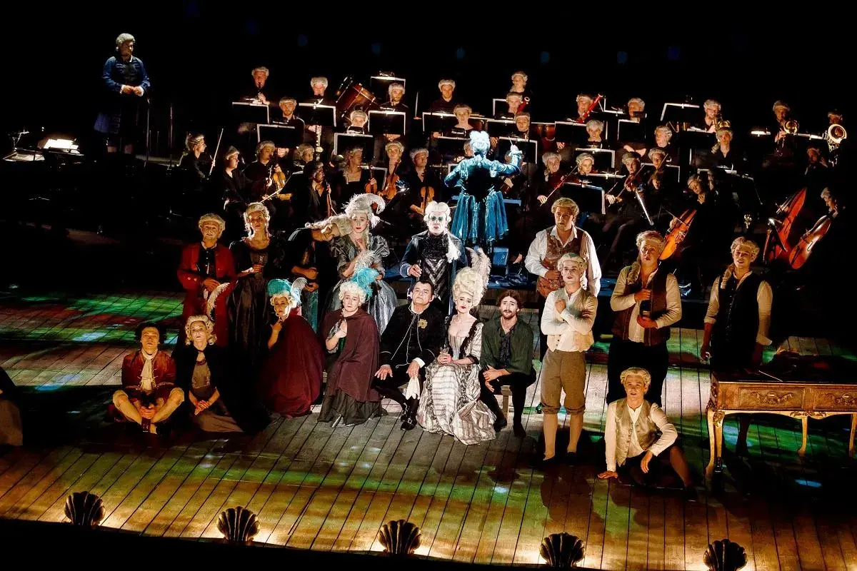 Aktorzy w strojach z epoki i orkiestra na scenie Teatru Dramatycznego w Płocku.