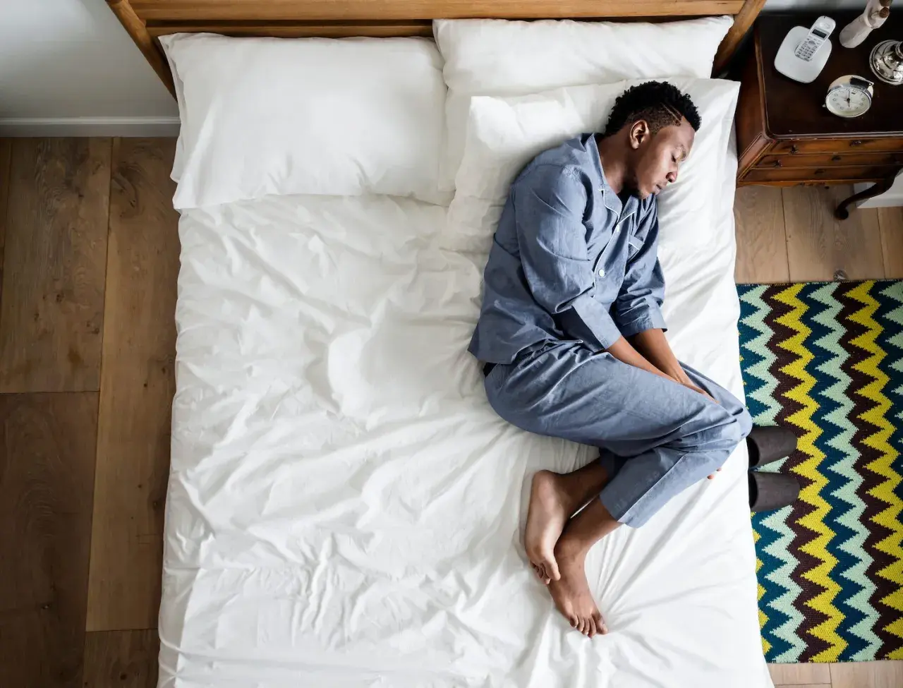 A man sleeps on his side, curled up. What does the way you sleep say about you?