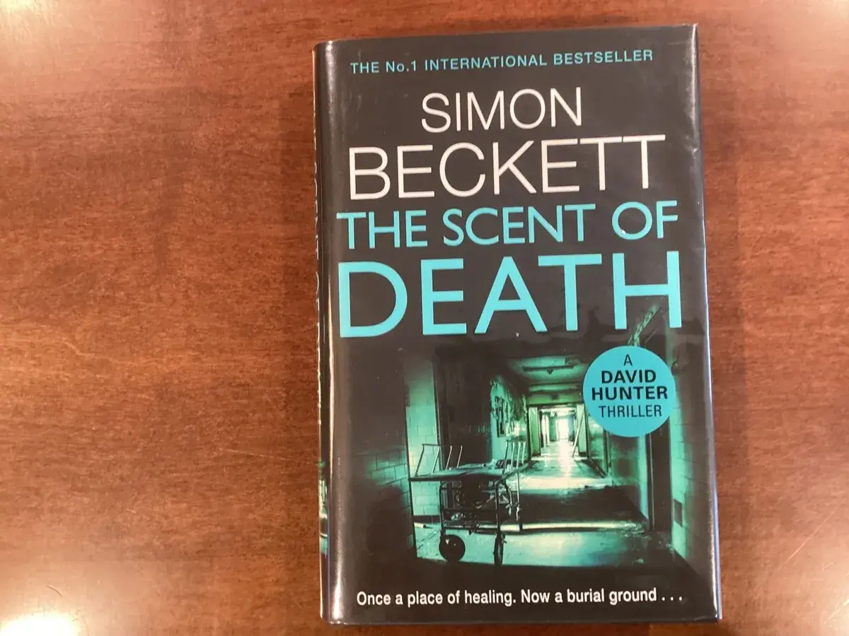 Buchcover "The Scent of Death" von Simon Beckett, Teil der David Hunter Reihe. Ein düsterer Flur mit einem Krankenwagen.
