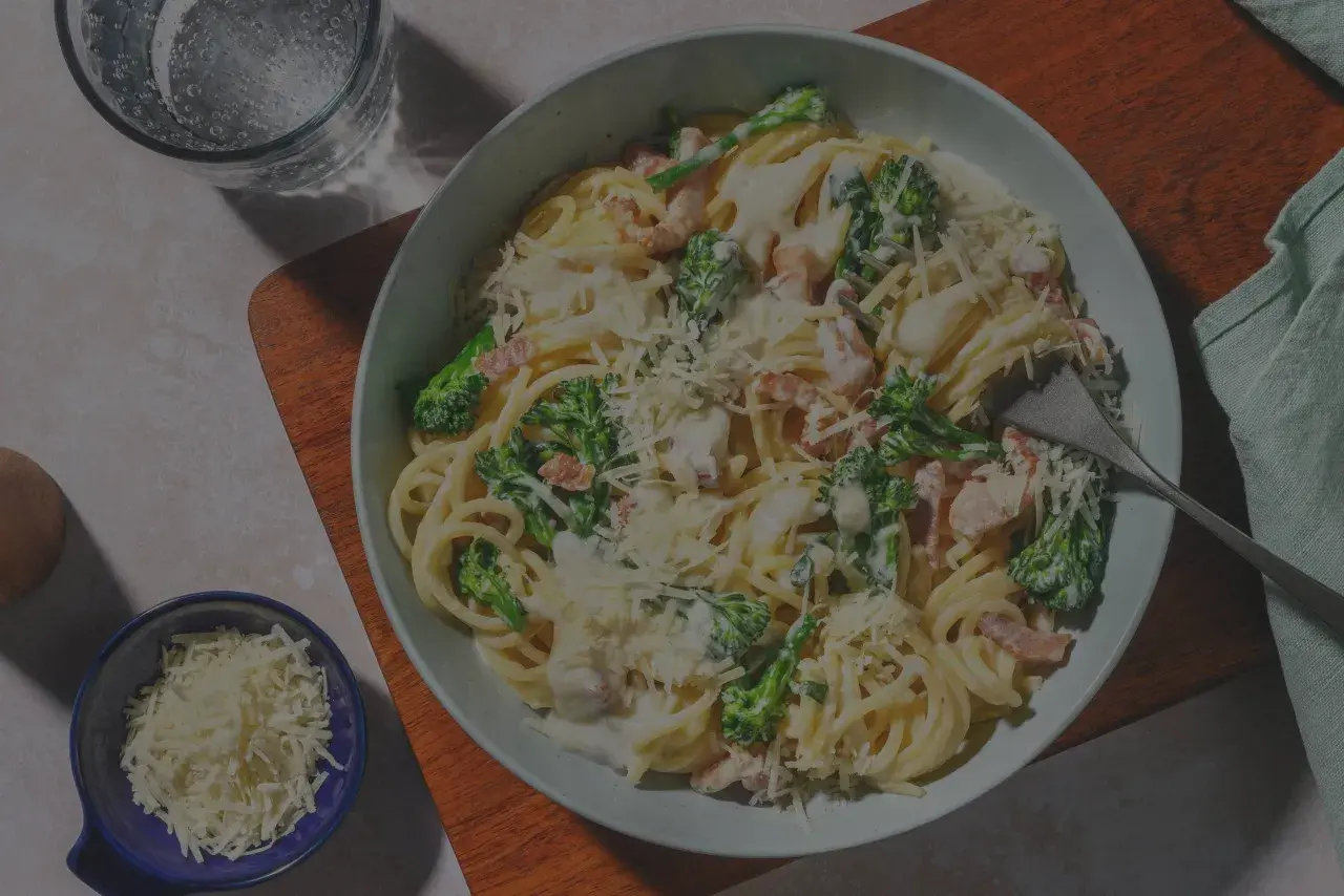 Ein Teller Spaghetti Carbonara, original italienisch, mit Brokkoli und Speck, bestreut mit Parmesan.