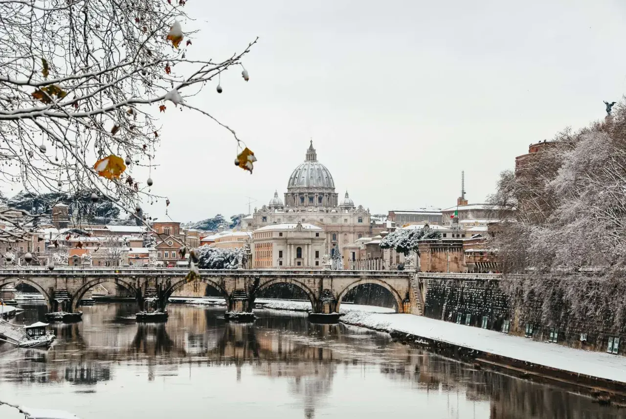 Roma innevata: la cupola di San Pietro e Ponte Sant'Angelo riflessi sul Tevere. Un raro freddo romano.
