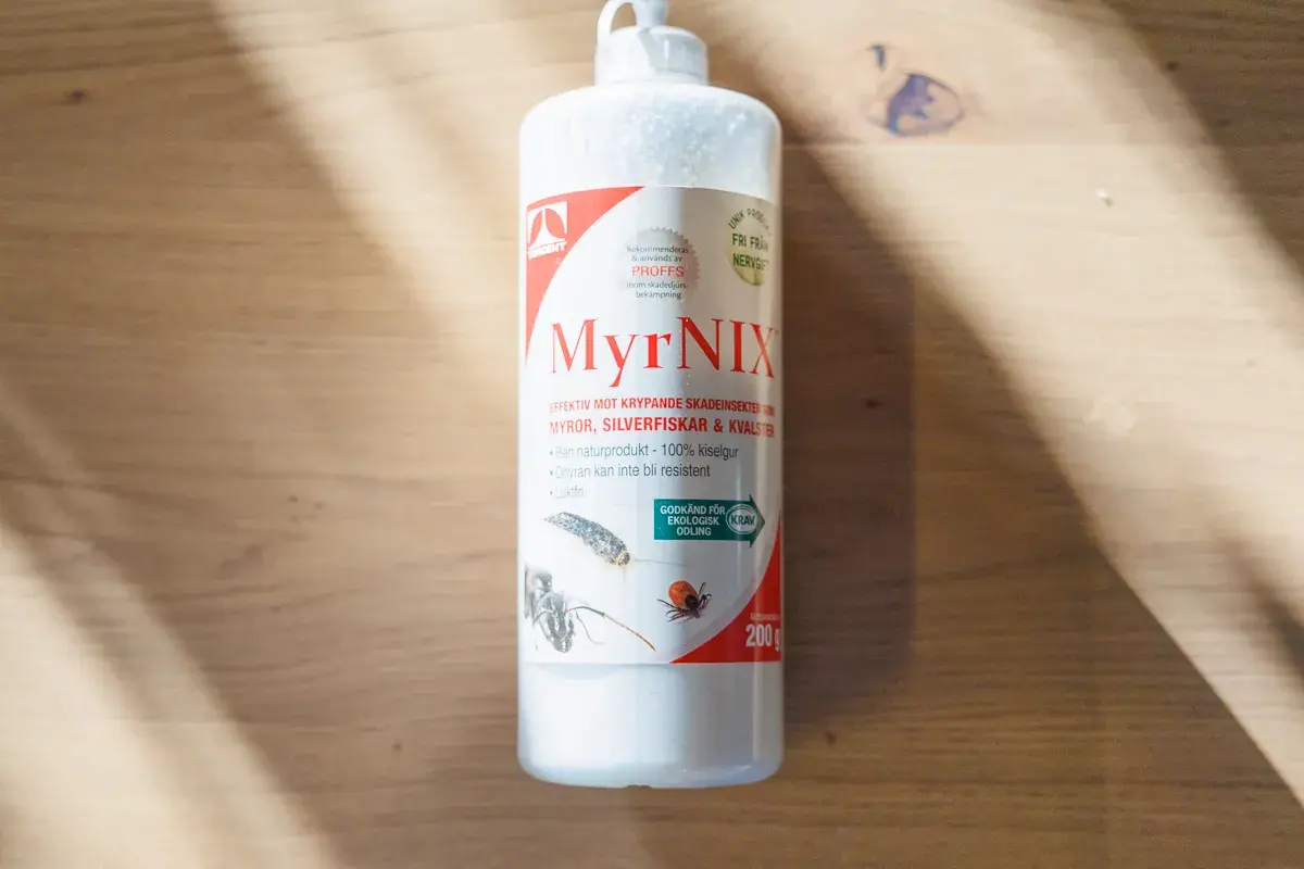 Flaska med MyrNIX, ett naturprodukt baserat på kiselgur, effektivt mot krypande skadeinsekter.