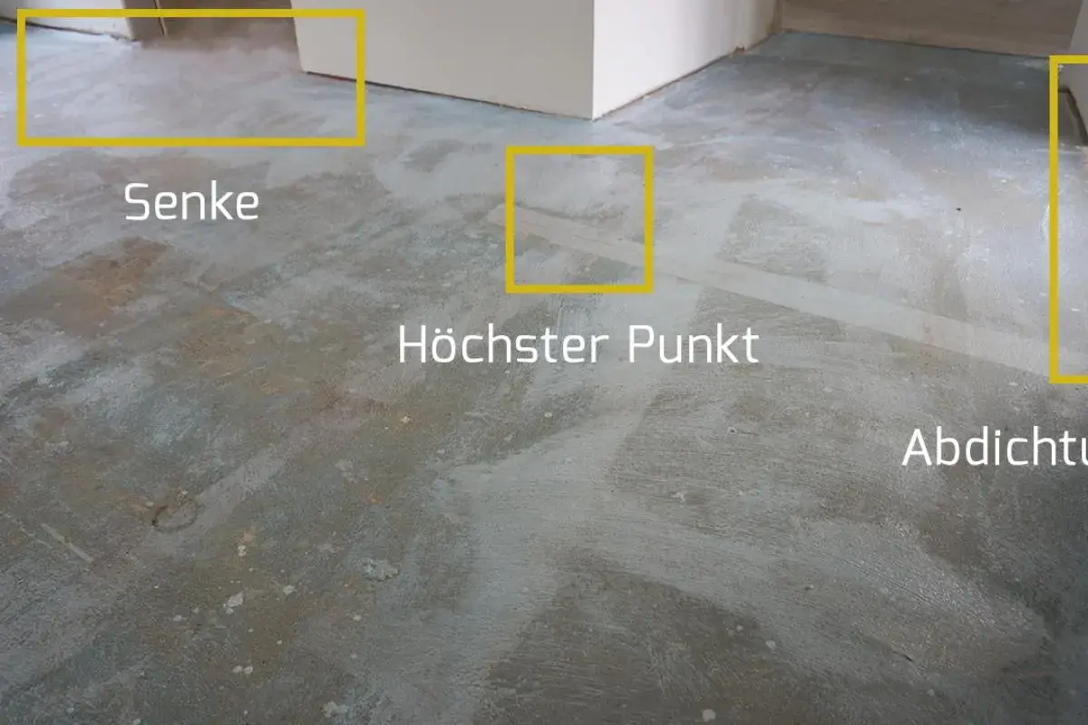 Der Boden wird vorbereitet, um die Ausgleichsmasse zu versiegeln. Markierungen zeigen Senken, den höchsten Punkt und die Abdichtung.