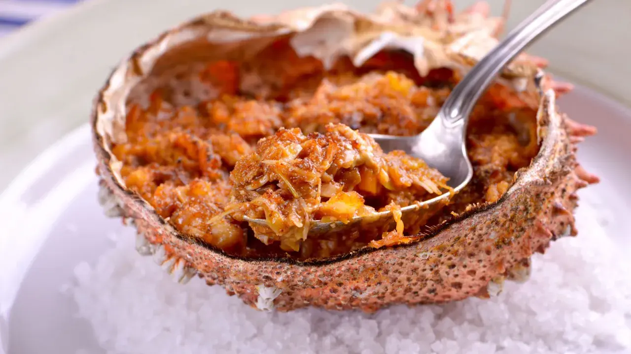 Txangurro a la donostiarra, un delicioso relleno de marisco en su caparazón, listo para ser degustado con una cuchara.