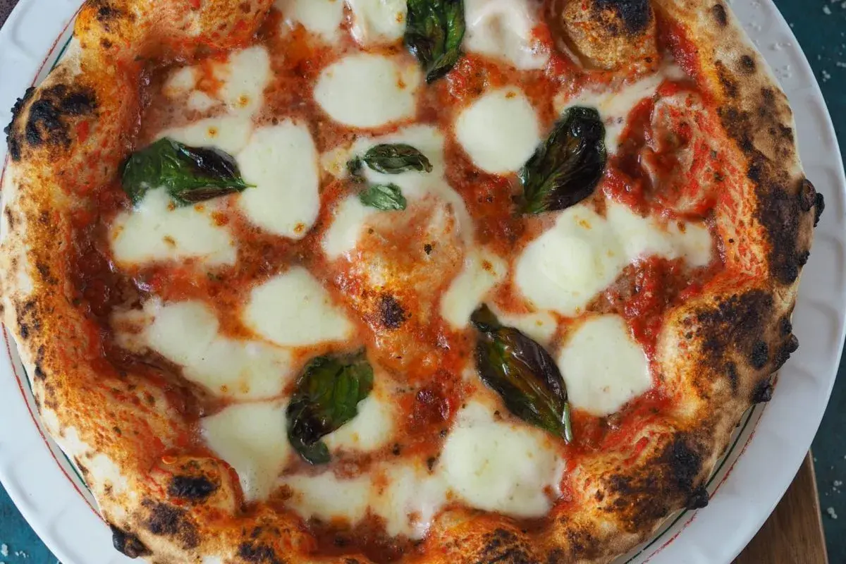 Eine perfekt gebackene Pizza Margherita mit geschmolzenem Mozzarella und frischem Basilikum.