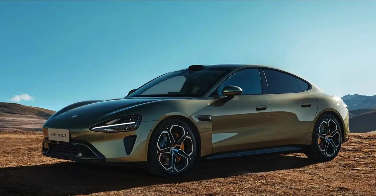 La nuova Xiaomi SU7, un'auto elettrica dal design audace, si presenta in un paesaggio desertico sotto un cielo azzurro.