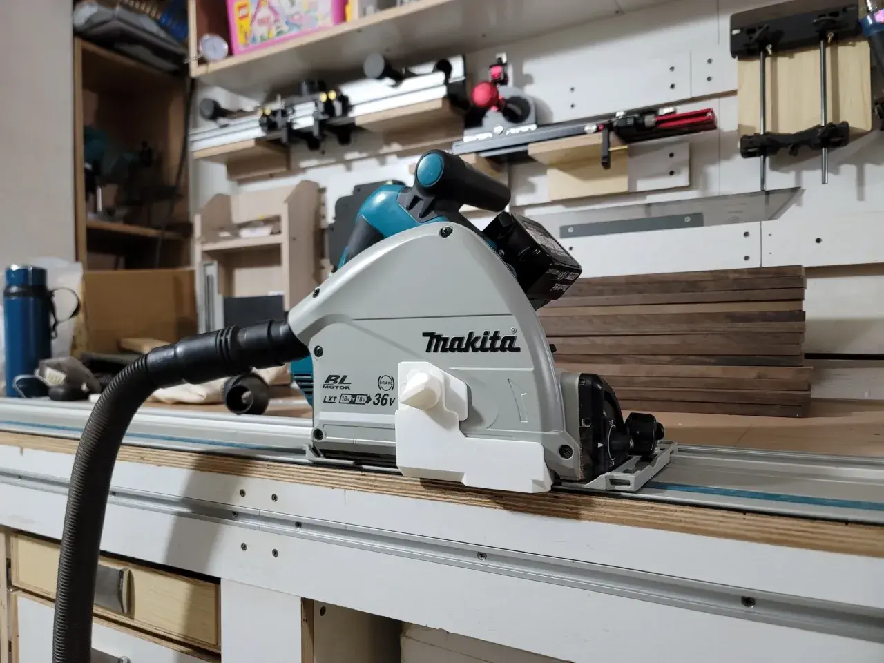 Sega circolare Makita su binario, pronta per tagliare profilo alluminio con precisione. Aspirazione collegata per un ambiente di lavoro pulito.