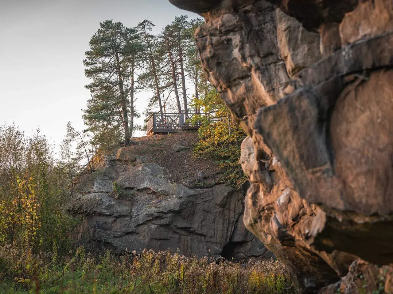 Kamienne miasto z platformą widokową wśród sosen. Skały tworzą naturalne miasto, a drewniana konstrukcja zaprasza do podziwiania krajobrazu.