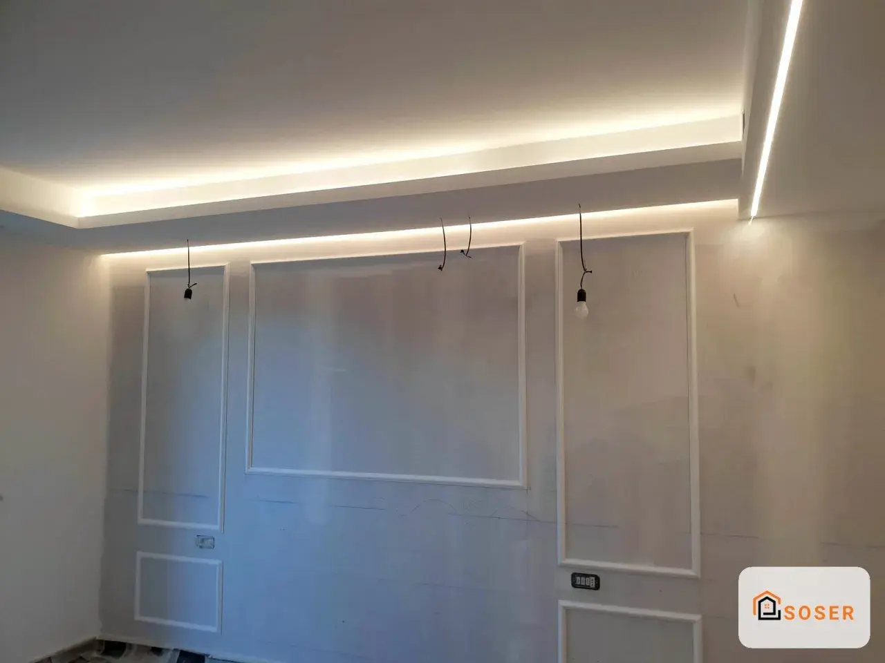 Soffitto in cartongesso con illuminazione a LED integrata e decorazioni a rilievo.