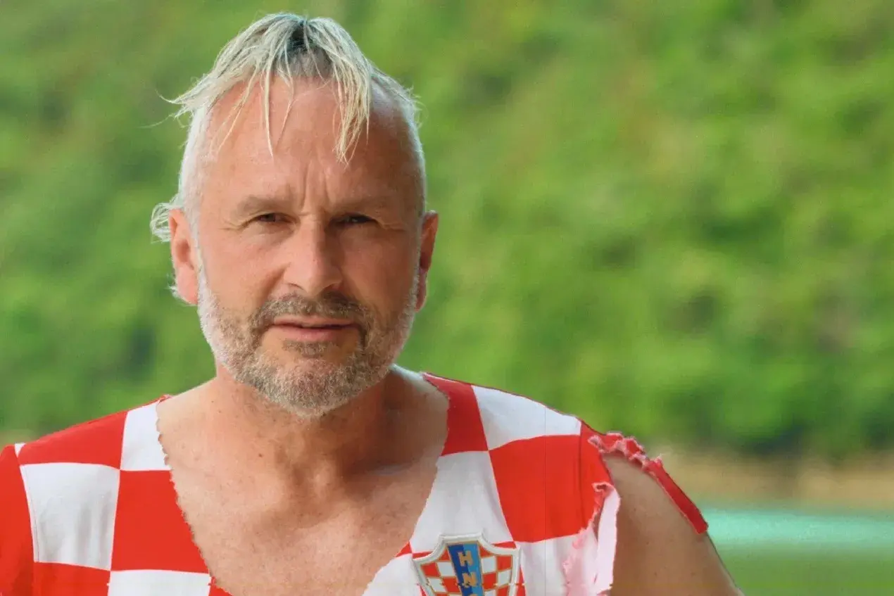 Fabian Turkalj, en man med grått hår och skägg, bär en sliten tröja med Kroatiens flagga.