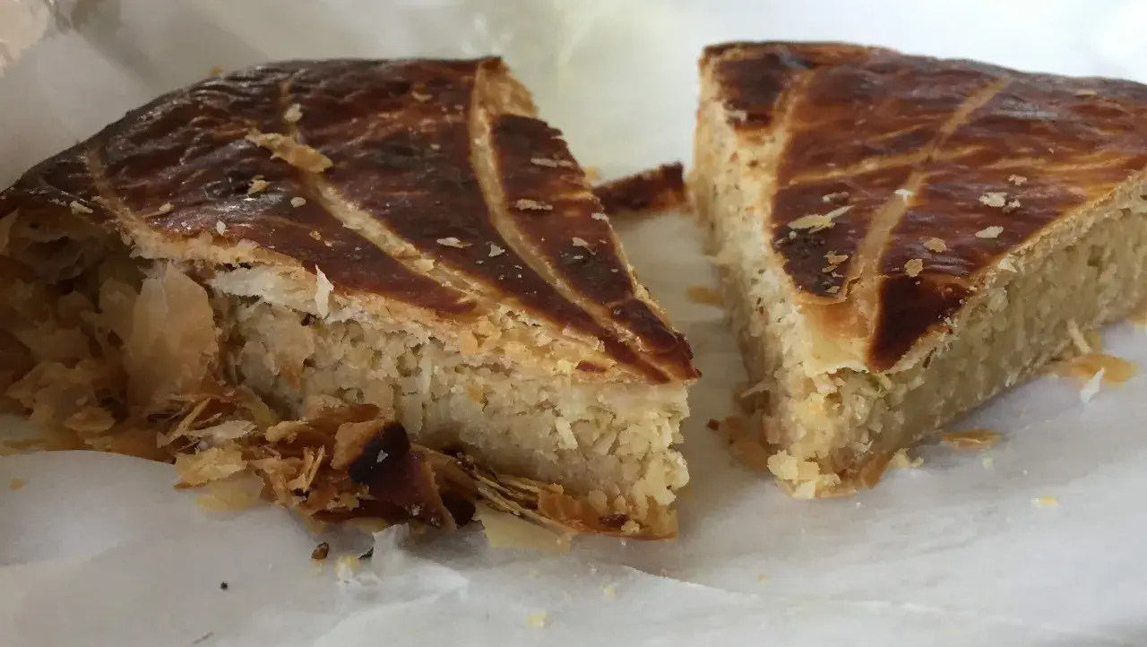Deux parts de galette des rois coco, avec leur feuilletage doré et leur garniture généreuse, prêtes à être dégustées.