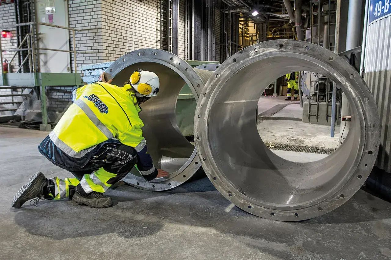Arbetare inspekterar stora rör vid Slite cementfabrik.