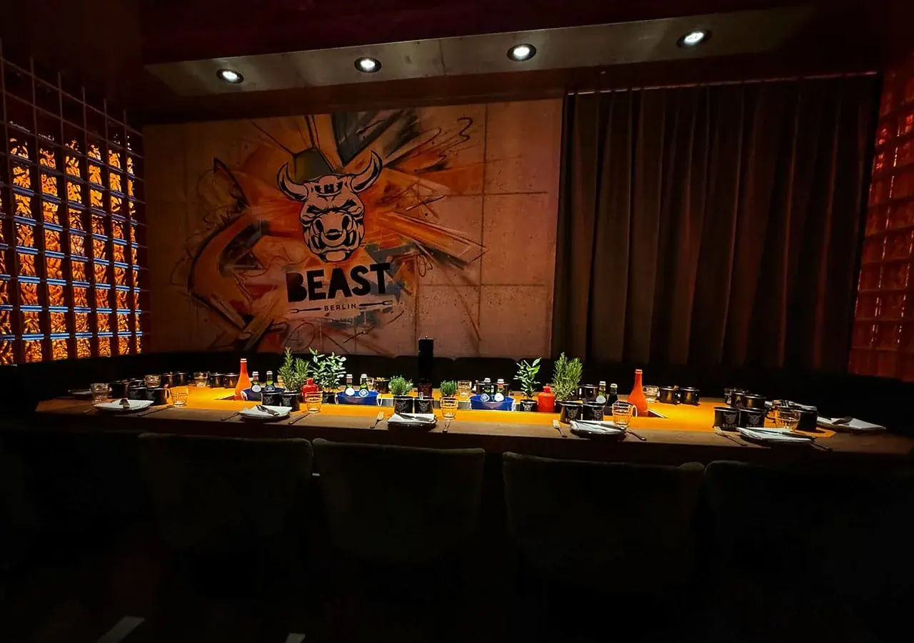 Ein festlich gedeckter Tisch im Alexanderplatz Restaurant "BEAST BERLIN" mit Graffiti-Wand und Glasbausteinen.