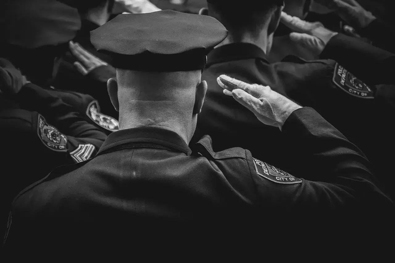 Policjanci w mundurach salutują. Dbanie o czystość munduru, jak prać mundur wojskowy, to ważny element służby.