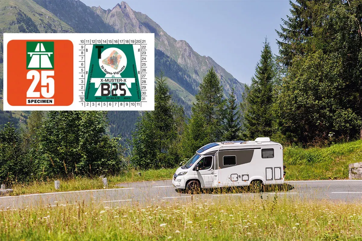 Un camping-car blanc roule sur une route de montagne en Suisse, avec une vignette autoroutière visible.