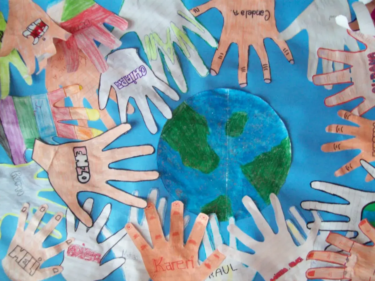 Manos de niños alrededor del planeta Tierra, celebrando actividades del Día de la Tierra.