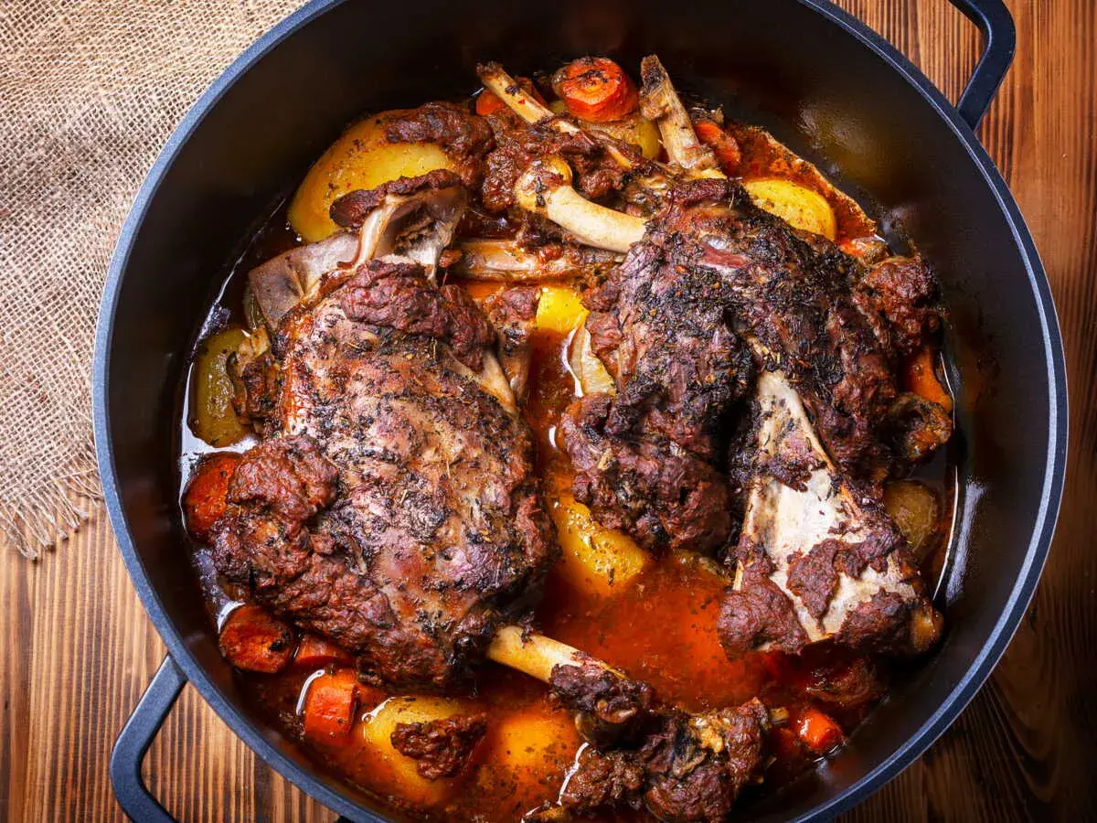 Épaule d'agneau en cocotte, tendre et savoureuse, mijotée avec des légumes racines dans un jus parfumé. Un plat réconfortant.