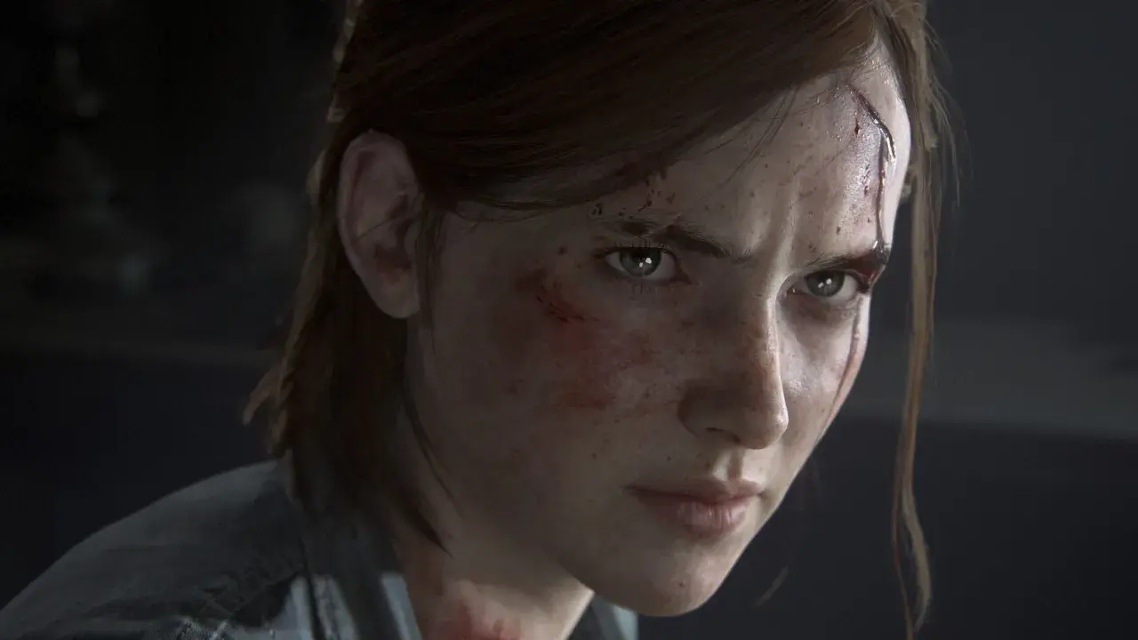 Twarz Ellie, naznaczonej bliznami i zadrapaniami, z determinacją w zielonych oczach.