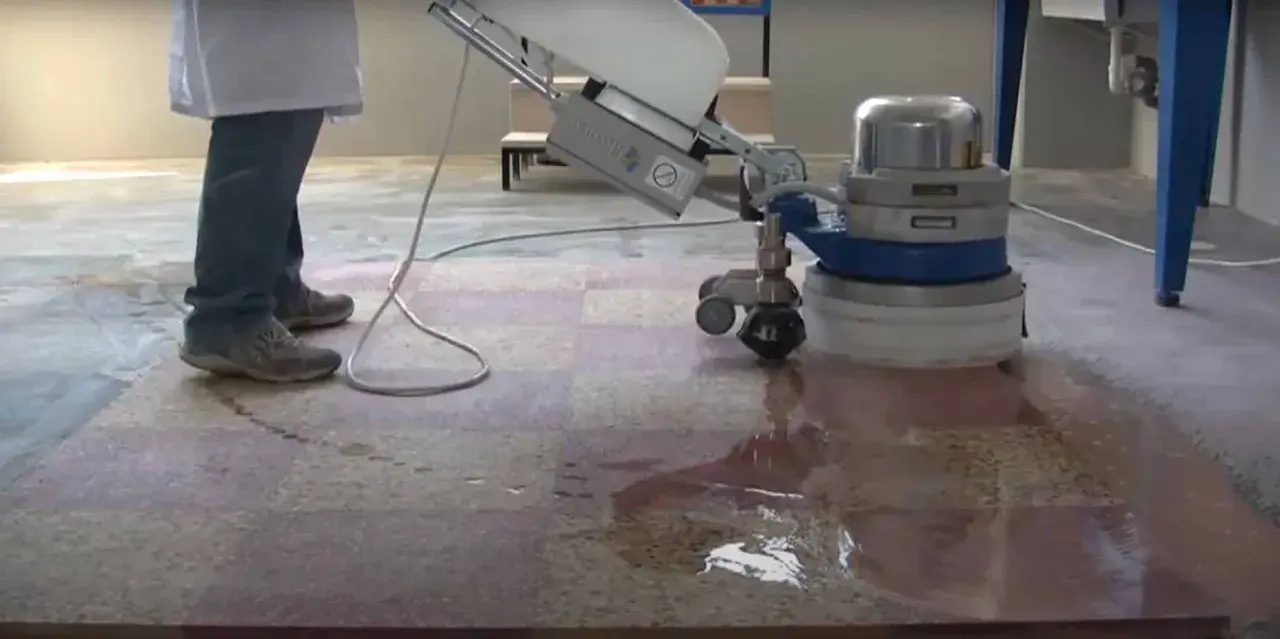 Une machine professionnelle est utilisée pour poncer le carrelage, laissant une surface propre et brillante.