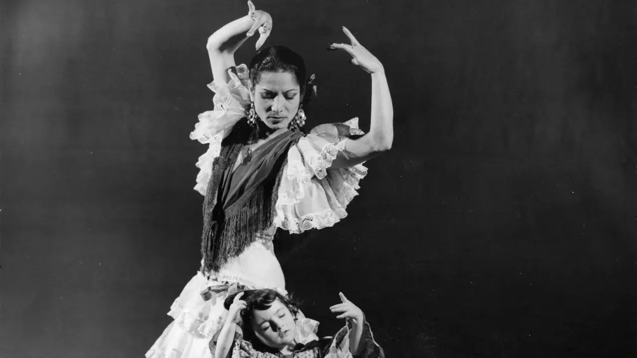 La familia Amaya flamenco, madre e hija bailan con pasión. La madre, con volantes y mantón, dirige la escena.