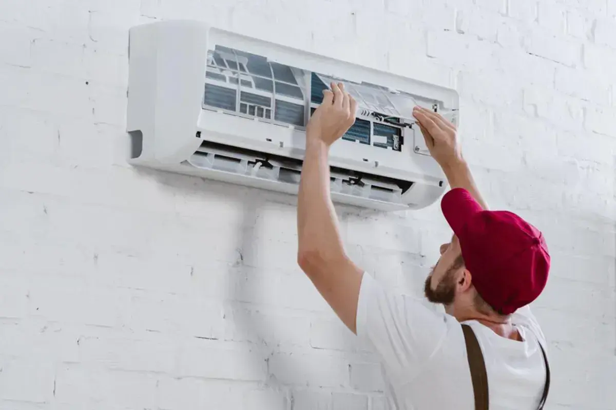 Técnico instalando un aire acondicionado inverter, ajustando filtros.