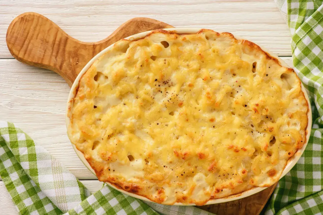 Delizioso pasta al forno bianca napoletana, dorata e filante, pronta per essere gustata.