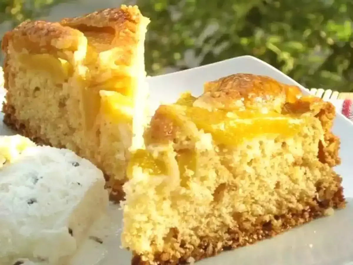 Fette di torta pesche e amaretti su un piatto bianco, con un pezzo di gelato.