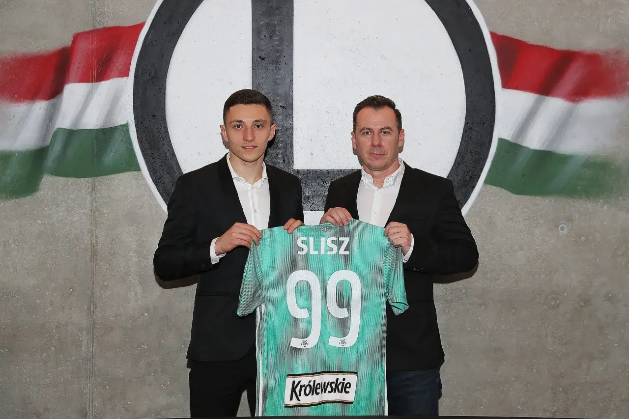 Dwóch mężczyzn prezentuje koszulkę z nazwiskiem SLISZ i numerem 99, symbolizującą rekord transferowy ekstraklasy.