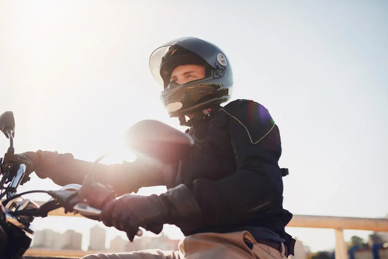 Giovane con casco integrale, pronto a partire in motorino. L'obbligo casco motorino è fondamentale per la sicurezza.